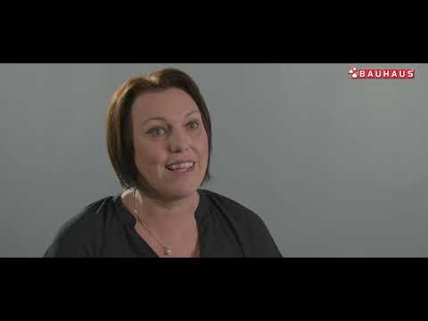 Lehrlingsportal.at Eine Frau mit kurzen braunen Haaren lächelt, während sie leicht aus der Kamera schaut; das Bauhaus-Logo erscheint in der oberen rechten Ecke.