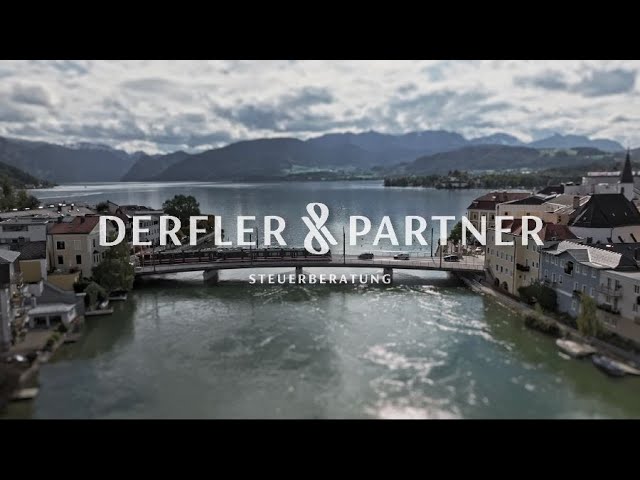 Lehrlingsportal.at Ein Fluss fließt durch eine Stadt mit einer Brücke und Gebäuden auf beiden Seiten, Berge im Hintergrund; der Text lautet "Derfler & Partner Steuerberatung".