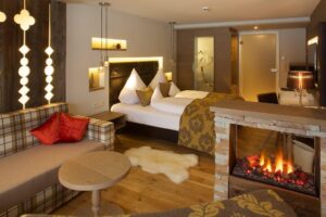 Hotelzimmer mit Doppelbett und Kamin