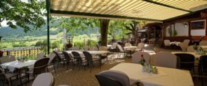 große Terrasse mit Tischen und Stühlen im Sommer