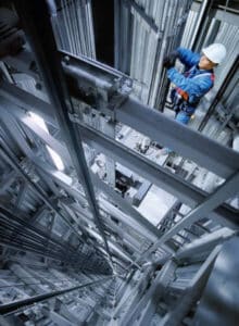 Mann in Arbeitsgewand und Schutzhelm arbeitet im Schacht