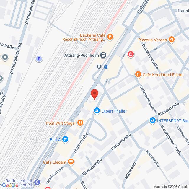 Lehrlingsportal.at Die Karte zeigt einen Abschnitt von Attnang-Puchheim, Österreich, mit verschiedenen Geschäften, Cafés und den Bahngleisen auf der linken Seite.