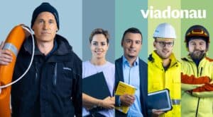 Lehrlingsportal.at Fünf Personen in unterschiedlicher Berufskleidung, die jeweils berufsbezogene Gegenstände in der Hand halten, stehen vor einem Hintergrund mit vertikalen Farbstreifen und dem "viadonau"-Logo.