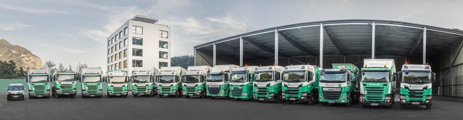 Lehrlingsportal.at Vor einem Lager- und Bürogebäude stand eine Reihe von dreizehn grün-weißen Sattelzugmaschinen der Marken Scania und DAF.