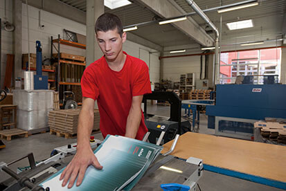 Druckerei Boesmueller Lehre Buchbinder Lehrling Rotes Shirt Bedient Maschine