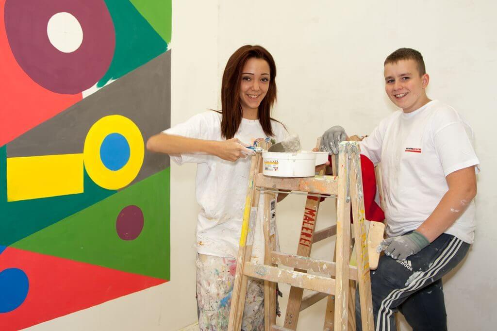 Lehrlinge Maler mit Leiter und Farbtopf